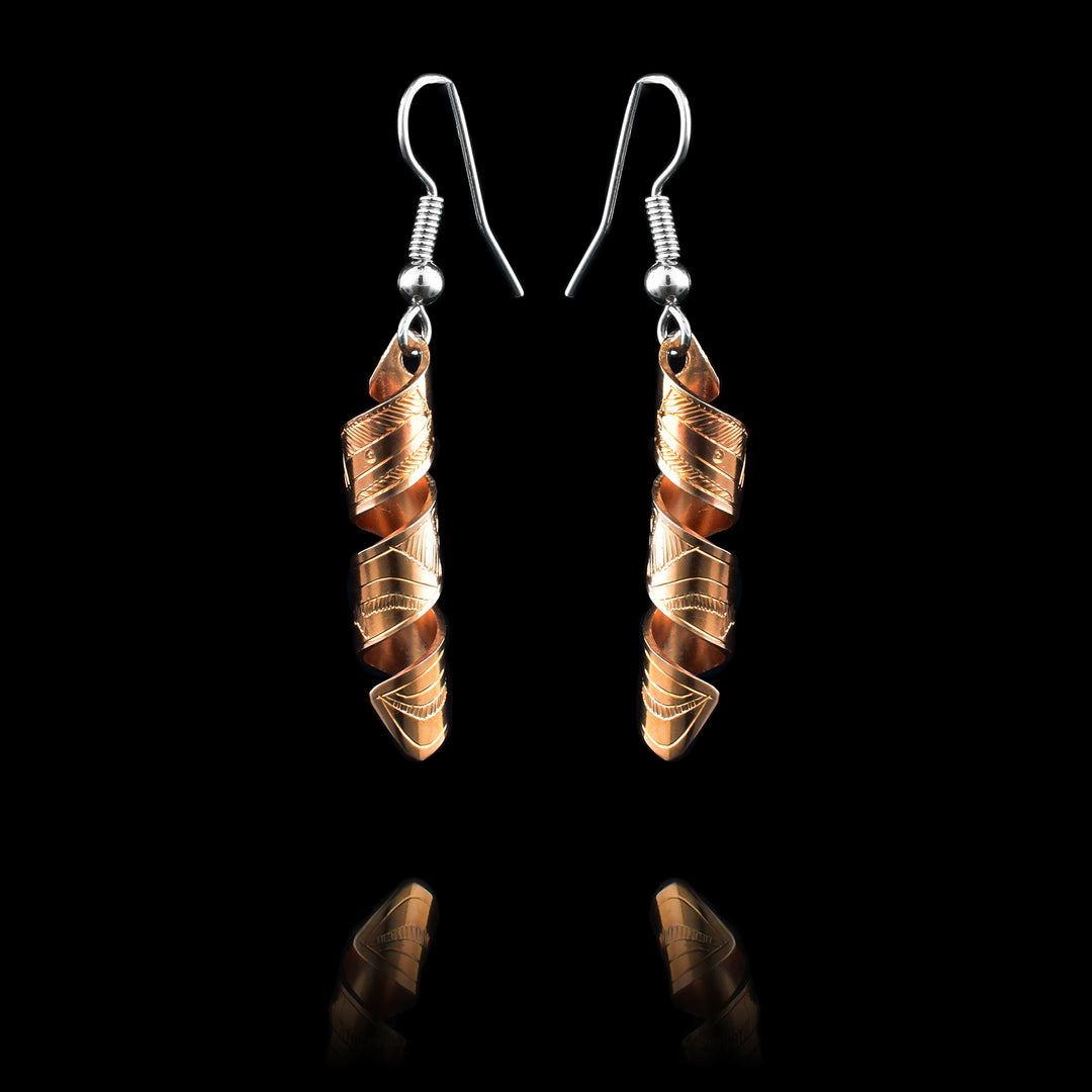 These spiral earrings have hangs made from copper bands that have been curved into horizontal spirals. These copper cylinders drop down and have carvings depicting a side view of the Hummingbird legend with their beaks facing upwards.