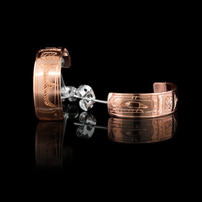 These wide hoop earrings are made from copper and has band curved back into a hoop with a gap in the back. There are depictions of the Hummingbird carved into the surface of the band.