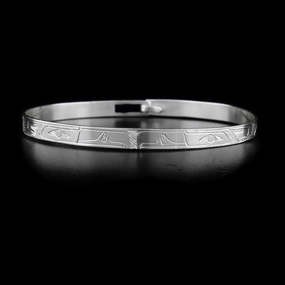 This sterling silver bracelet has the heads of the Orca and the Hummingbird carved on the front, facing each other. Their bodies are engraved on the rest of the bracelet.