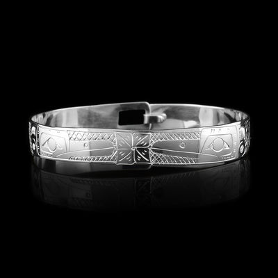 This Hummingbird and flower bracelet has a single, sterling silver band with a clasp in the back. There are two depictions of the Hummingbird carved into the band. The legends are depicted facing each other and there are flowers carved in the center of it.