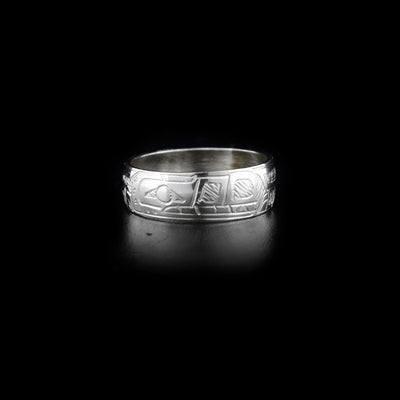 This sterling silver band ring has a single band with a depiction of the Wolf carved into it.