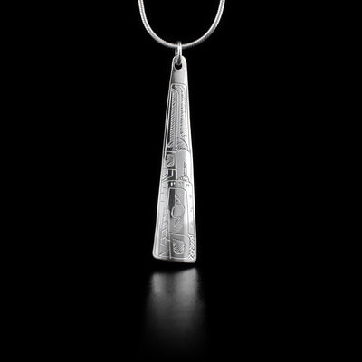 This sterling silver pendant is long, thin, and wider at the bottom. A depiction of the Bear is carved into it.