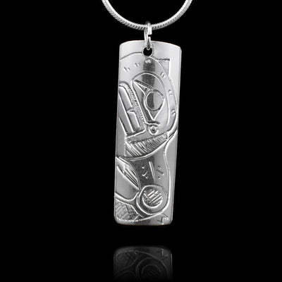 This sterling silver pendant is a small rectangle. There is a depiction of the Bear and a depiction of the Salmon carved onto to either side of this double sided, carved pendant.