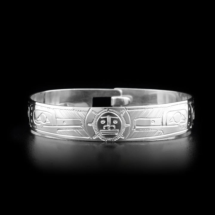 This sterling silver clasp bracelet has two depictions of the Hummingbird and a depiction of the Sun carved into the band. The Hummingbirds are depicted facing the Sun and there is a clasp at the back of the bracelet.
