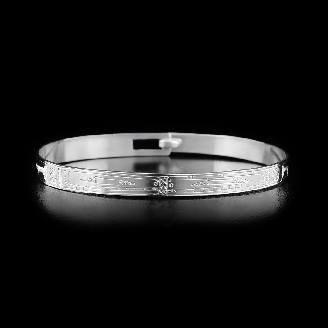 This Orca bracelet is made from sterling silver. The bracelet has a thin band with two depictions of the Orca carved into the surface of it.