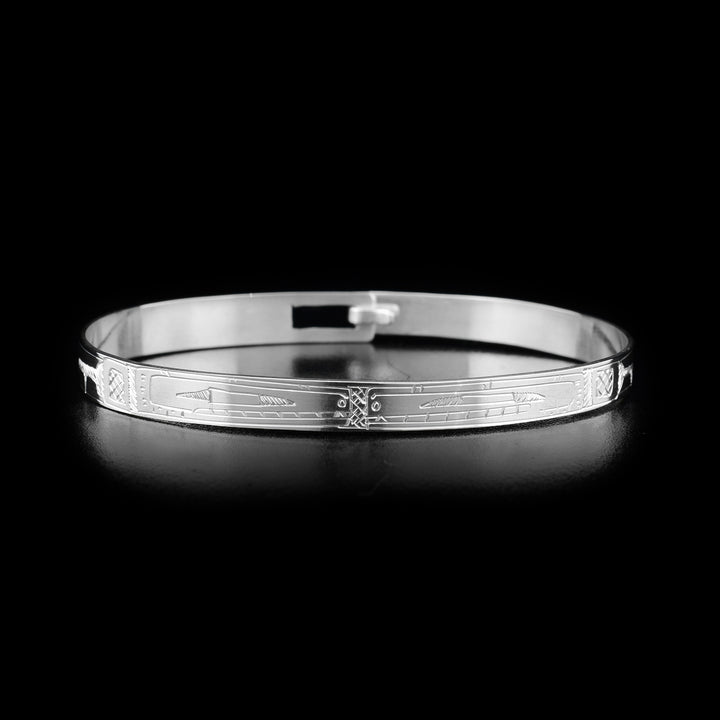 This Orca bracelet is made from sterling silver. The bracelet has a thin band with two depictions of the Orca carved into the surface of it.