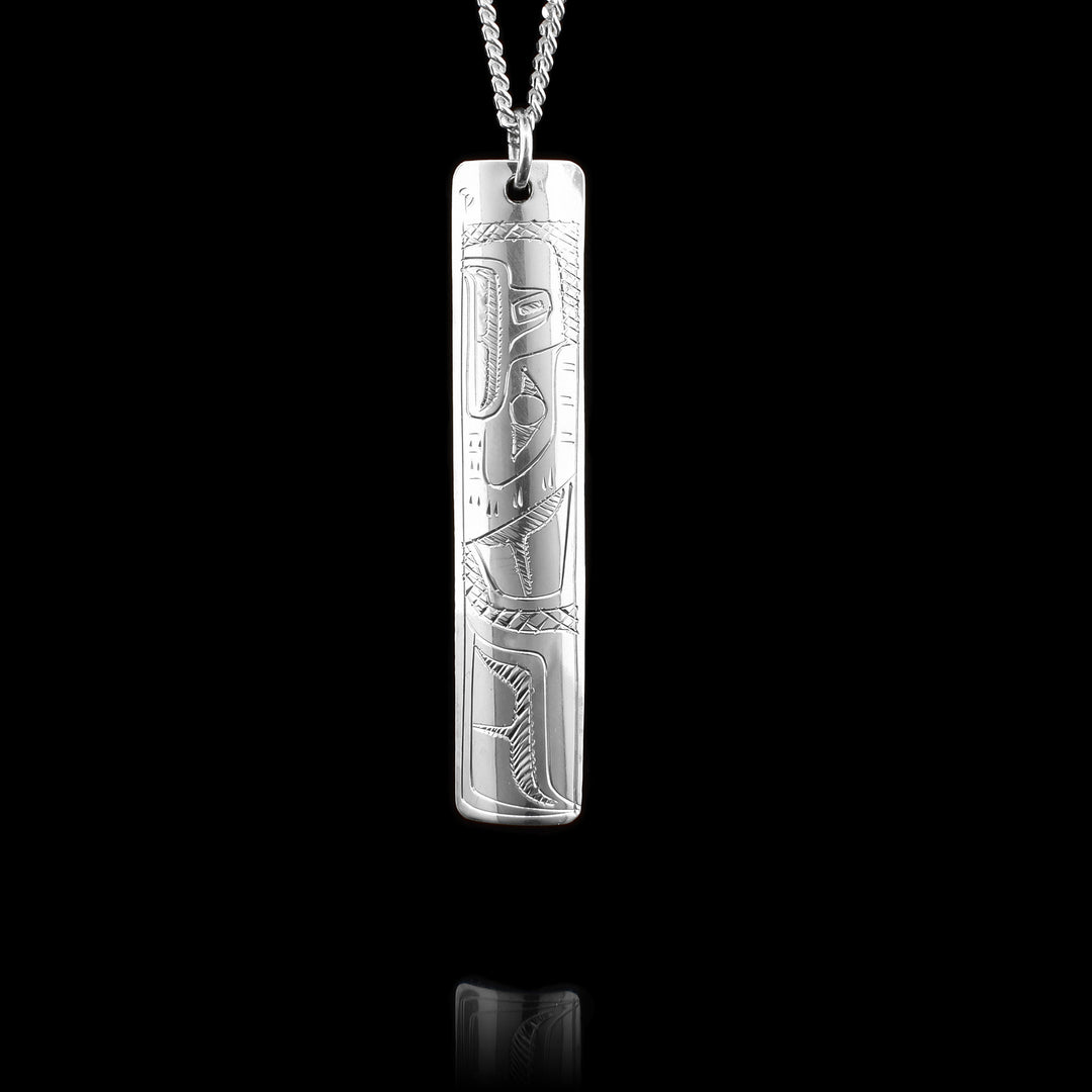 This Hummingbird and Eagle pendant is made from sterling silver and has a long, thin and rectangular shape to it. There are designs on both sides of the piece, on one side there is a depiction of the Eagle carved into it and on the other there is a depiction of the Hummingbird.