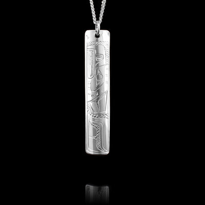 This Hummingbird and Eagle pendant is made from sterling silver and has a long, thin and rectangular shape to it. There are designs on both sides of the piece, on one side there is a depiction of the Eagle carved into it and on the other there is a depiction of the Hummingbird.
