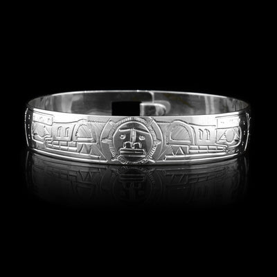 This Wolf and Moon bracelet is made from sterling silver. There are two depictions of the Wolf and a depiction of the Moon carved into the band. The two Wolves are depicted facing the Moon.