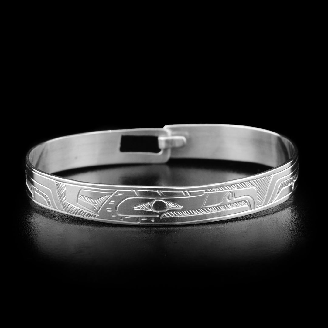 This baby's silver bracelet is made form sterling silver and has a single band with a clasp in the back. There is a depiction of the Eagle carved into the band.