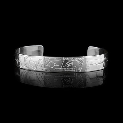 This sterling silver cuff bracelet has a thin band and there is a depiction of the Eagle carved into the surface of it.