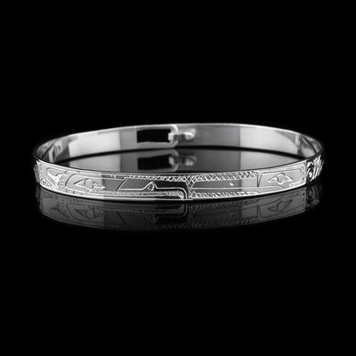 This dainty Eagle and Hummingbird bracelet has a thin, sterling silver band with a clasp in the back. There are depictions of the Eagle and the Hummingbird carved into the surface of the band. The legends are depicted facing each other. 