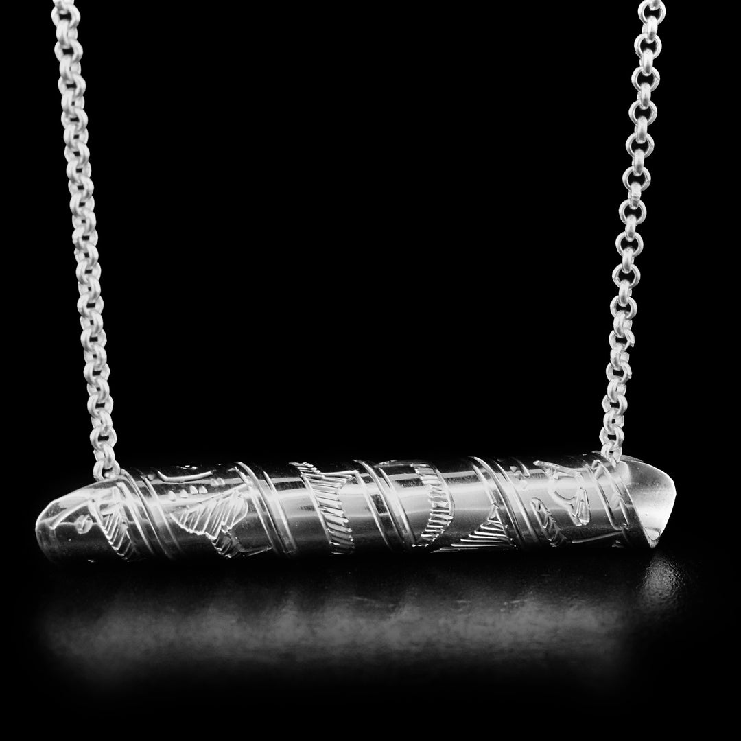 This pendant is made out of a sterling silver strip which has the face and body of the Eagle carved on it and then coiled into a spiral.