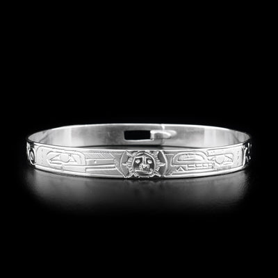 This sterling silver clasp bracelet has depictions of the Hummingbird, the Bear, and the Sun carved into the band. The Sun is depicted at the top of the bracelet and there is a clasp in the back.