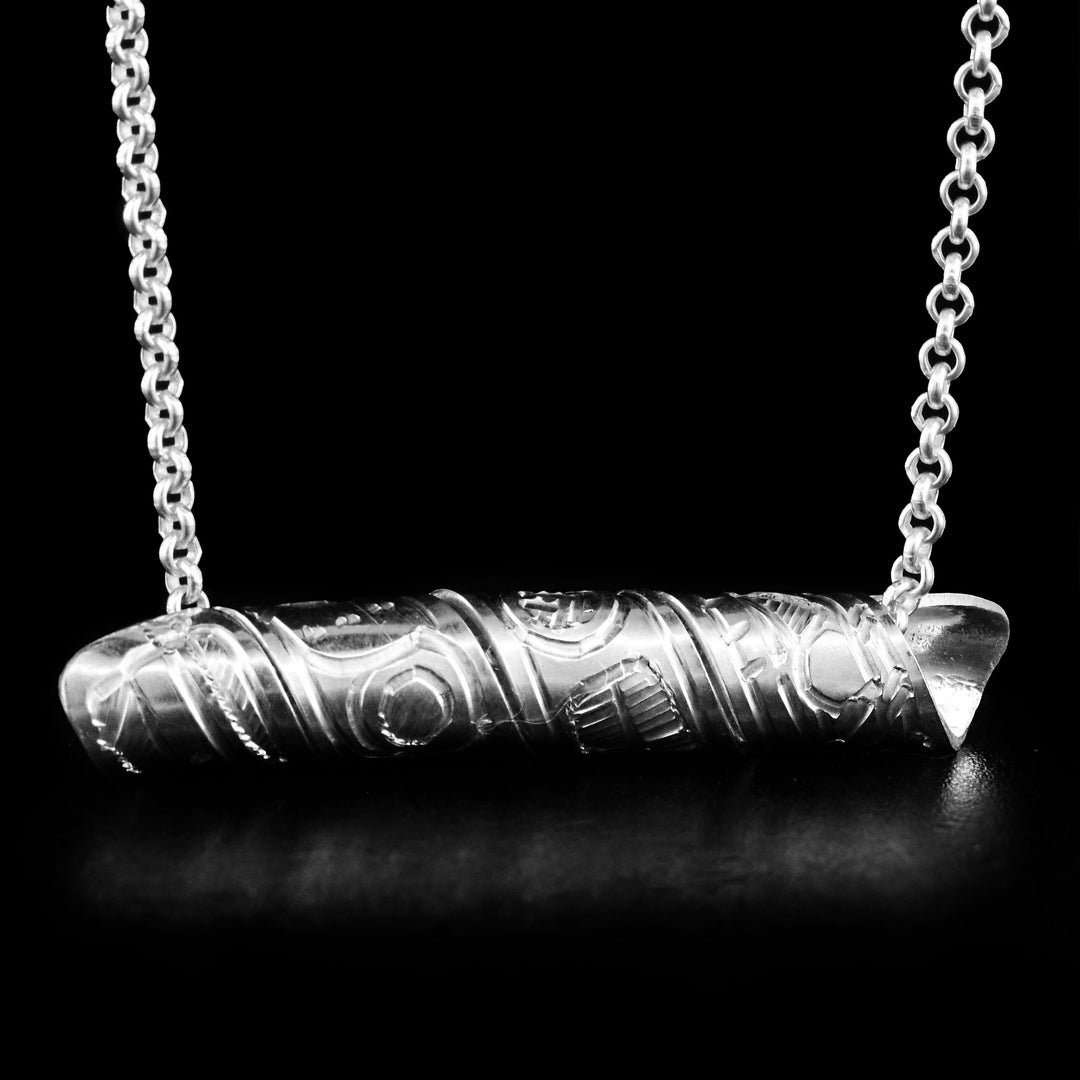 This pendant is made out of a sterling silver strip which has the face and body of the Hummingbird carved on it and then coiled into a spiral.