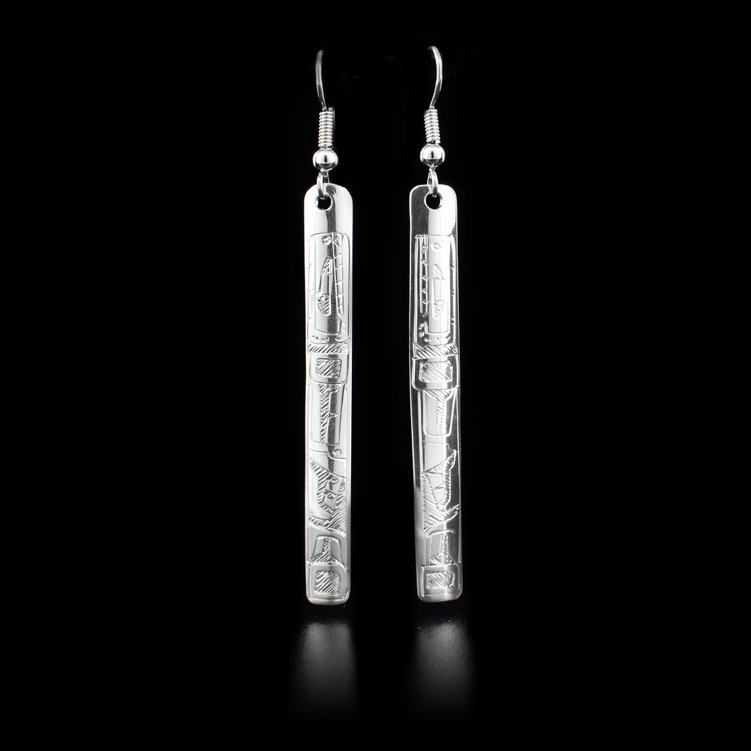 These sterling silver earrings depict the face of the Orca. The earrings have hooks which have long rectangular hangs.