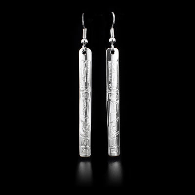These sterling silver earrings depict the face of the Orca. The earrings have hooks which have long rectangular hangs.