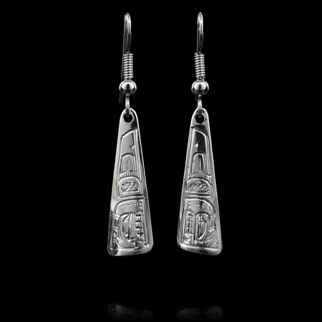 These dangling Orca earrings are made from sterling silver and have long, tapered hangs. There are designs carved into the surface of the hangs depicting the Orca.
