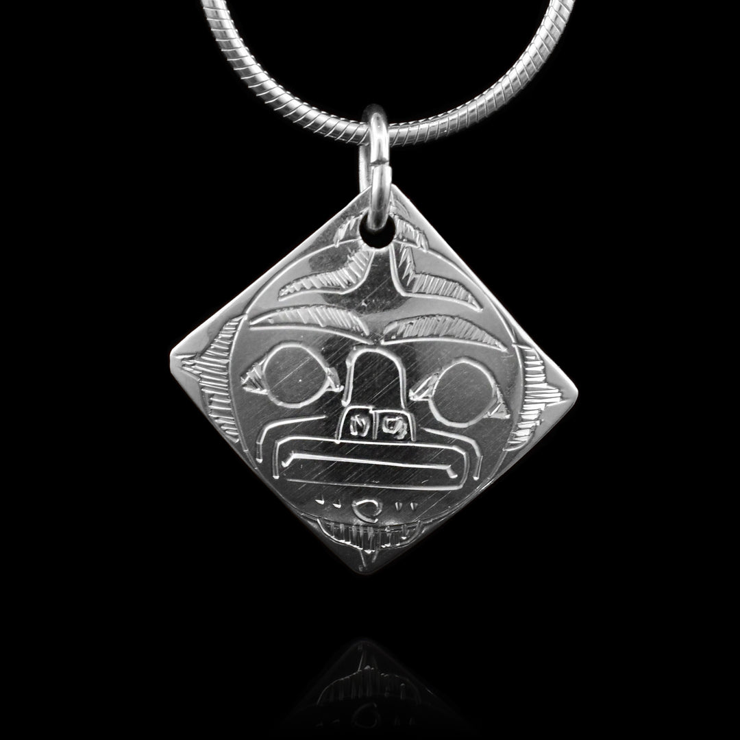 This sterling silver Moon pendant is diamond shaped and there are carvings that depict the Moon on the surface of it.