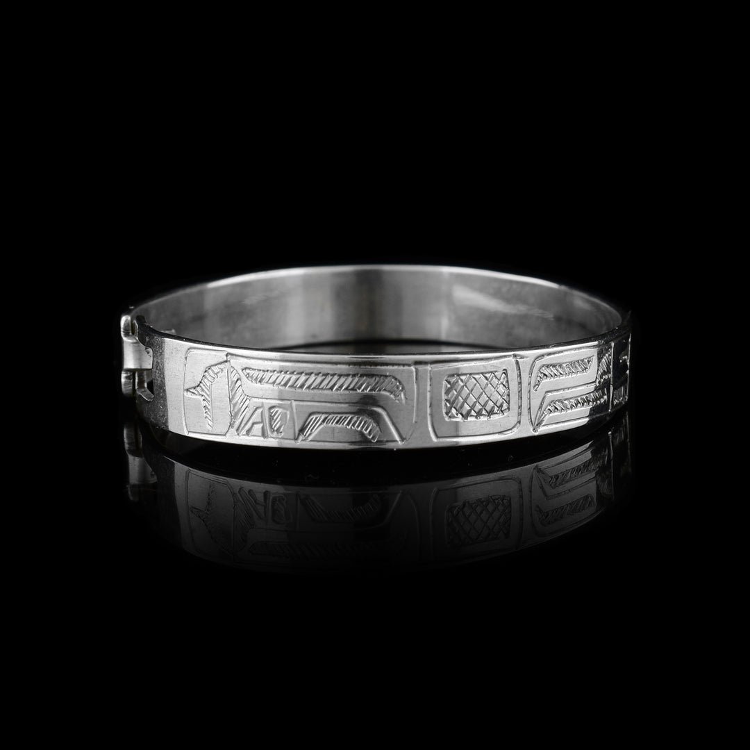 This baby's silver bracelet is made form sterling silver and has a single band with a clasp in the back. There is a depiction of the Orca carved into the band. The head is in the center of the band with the details of its body spanning across the band.