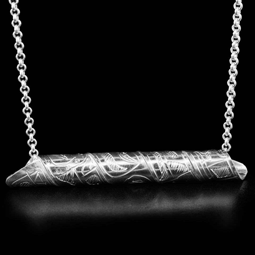 This pendant is made out of a sterling silver strip which has the face and body of the Orca carved on it and then coiled into a spiral.