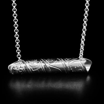 This Orca spiral pendant is made form a sterling silver band that has been coiled into a horizontal cylinder. There is a depiction of the Orca carved into the band.