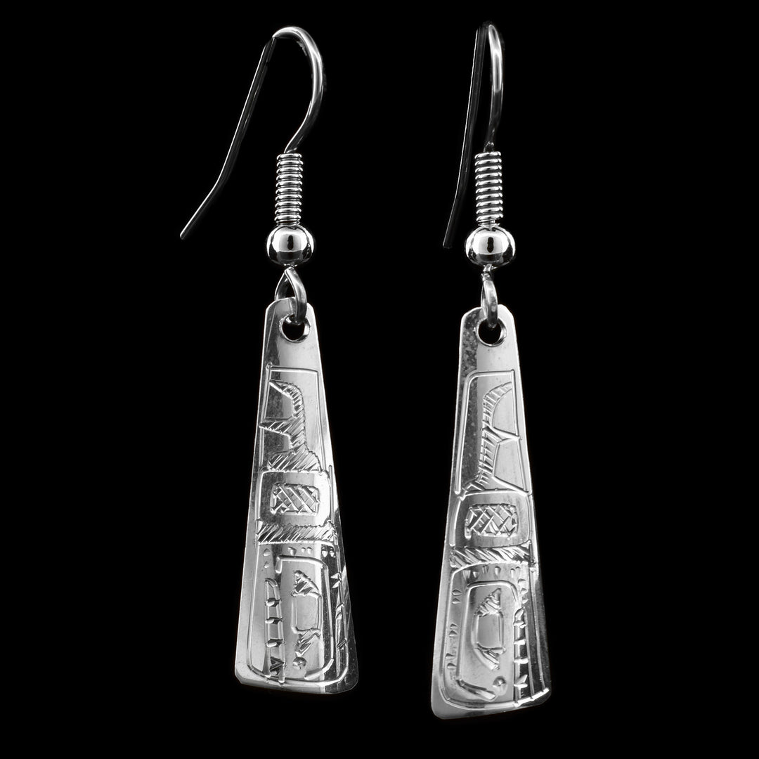 These dangling Orca earrings are made from sterling silver and have long, tapered hangs. There are designs carved into the surface of the hangs depicting the Orca.