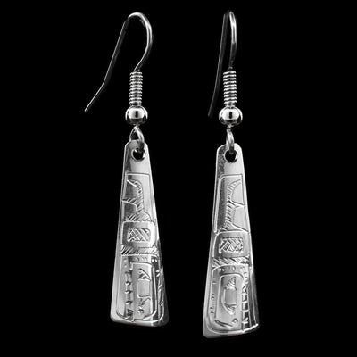 These dangling Orca earrings are made from sterling silver and have long, tapered hangs. There are designs carved into the surface of the hangs depicting the Orca.