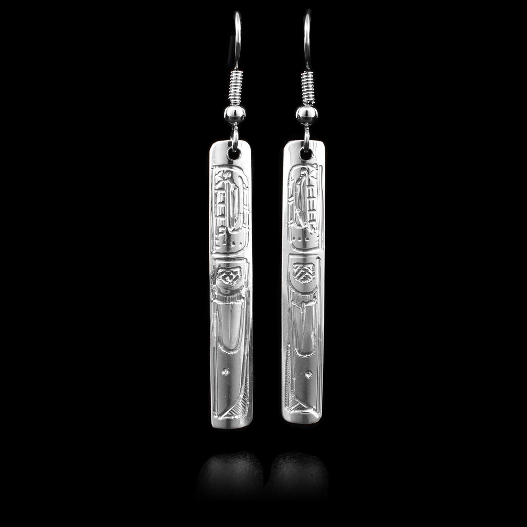 These sterling silver dangle earrings have long, thin, rectangular hangs with depictions of the Orca carved into them.