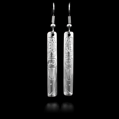 These sterling silver dangle earrings have long, thin, rectangular hangs with depictions of the Orca carved into them.