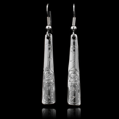 These dangling Orca earrings are made from sterling silver and have long, thin and tapered hangs. There are carvings on the surface of the hangs depicting the Orca.