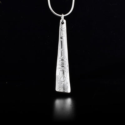 This sterling silver pendant is thin, long, and wider at the bottom. There is the Orca carved into it.