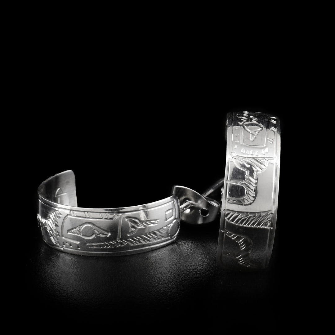 Sterling silver wide silver hoop earrings that measure 1/4" by 3/4". The hoops are made of a flat piece of sterling silver which has the Raven holding the Sun in its beak engraved on it. 