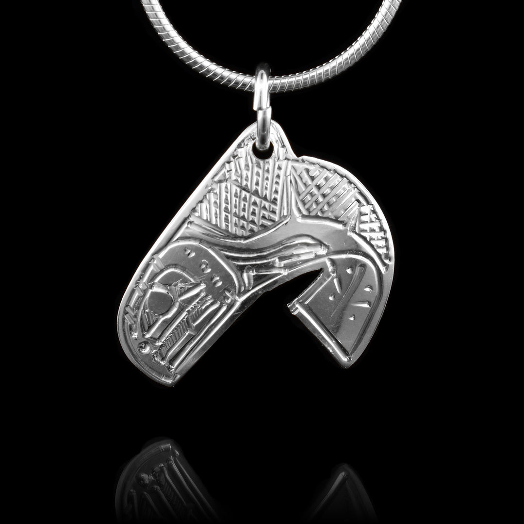 This sterling silver pendant is shaped like and has carvings on it that depict the Salmon.