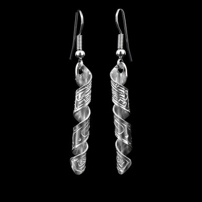 These sterling silver dangle earrings have long hangs that are coil shaped. There are depictions of the Orca carved into the surface of the hangs.