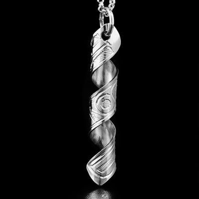 This pendant is made out of a sterling silver strip which has the face and body of the Hummingbird carved on it and then coiled into a spiral.