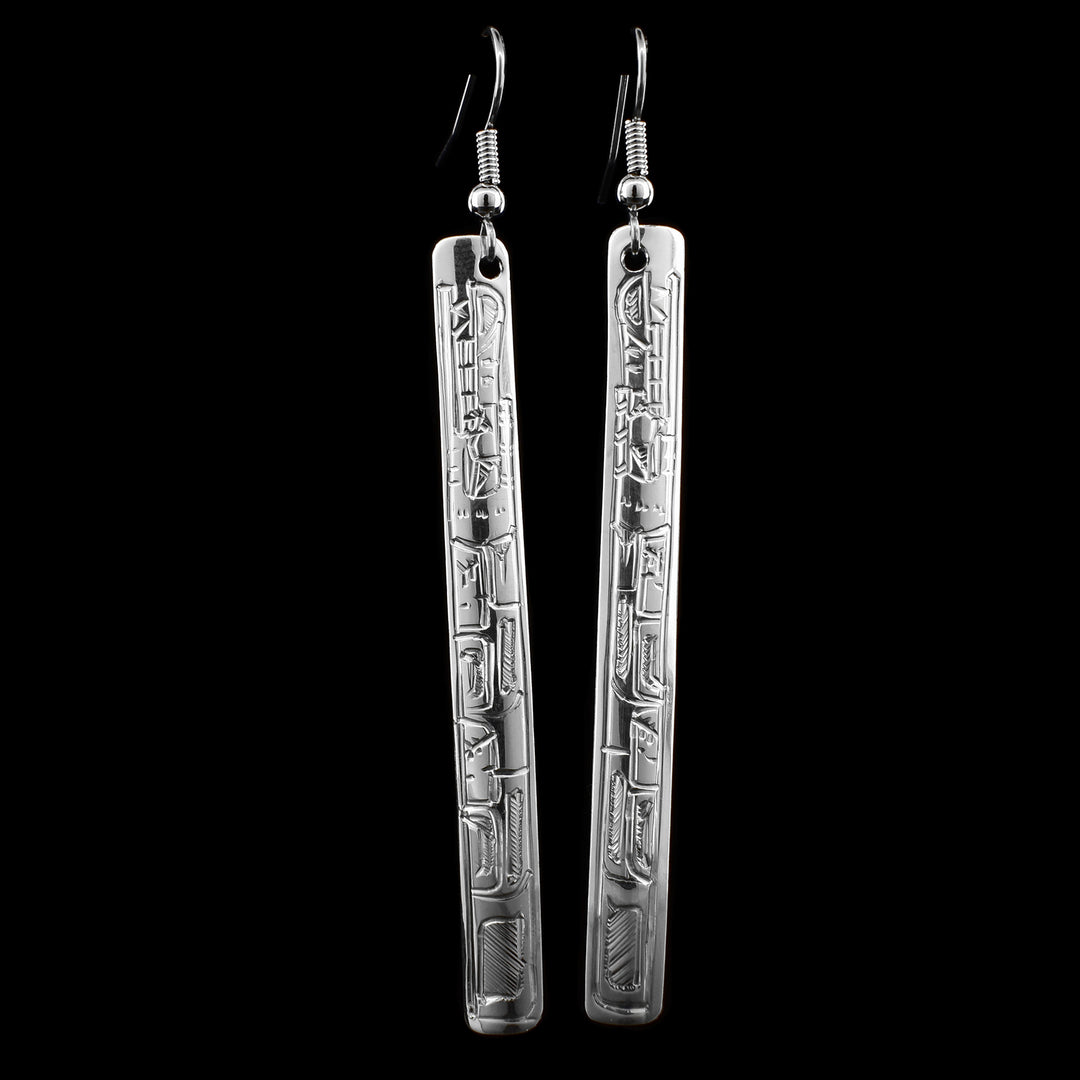 These long earrings are made from sterling silver and have long, thin and rectangle shaped hangs. There are depictions of the Wolf that have been beautifully carved into the surface of the hangs.