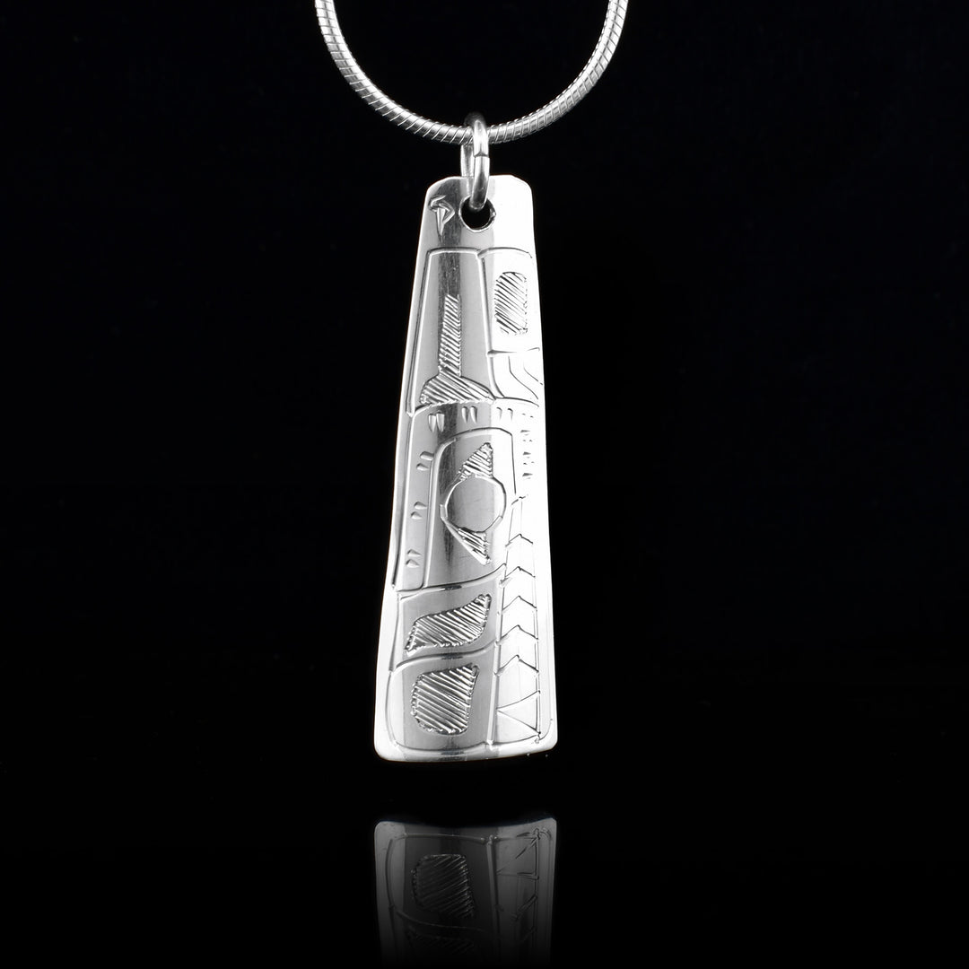 This Wolf pendant is made from sterling silver and is rectangular and slight tapered. There is a depiction of the Wolf carved into the surface of the pendant..