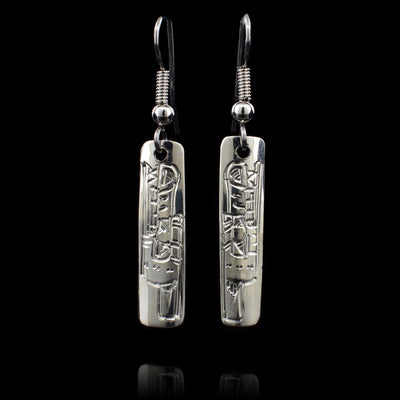 These sterling silver dangle earrings are rectangle shaped and there are depictions of the Wolf carved into the hangs.