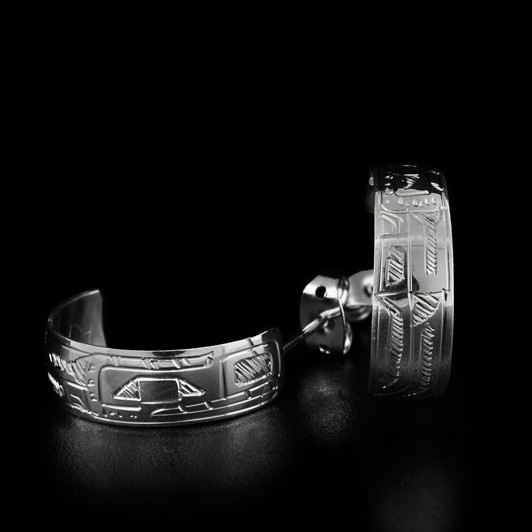 These wide silver hoop earrings that are made out of a flat piece of sterling silver that has the Bear's face carved on it. Each earring measures 1/4" in width and 3/4" in length.
