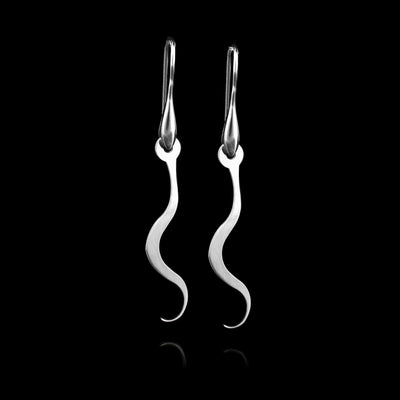 These sterling silver dangling earrings have thin hangs that depict a Haida Gwaii character.