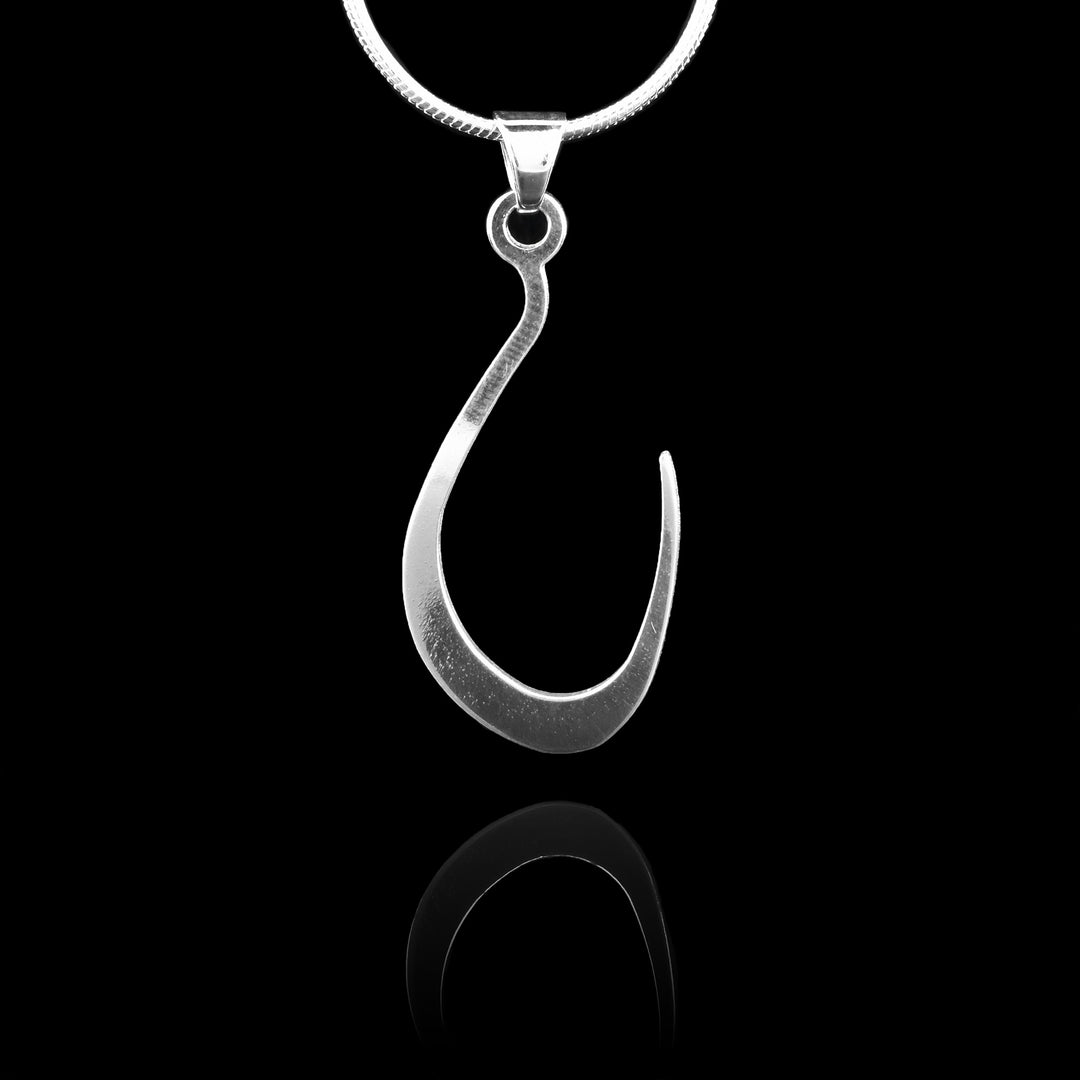 These sterling silver pendants drop down and curve up into a hook shape. The piece represents a Haida Gwaii character.