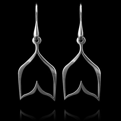 These sterling silver dangling earrings have thin hangs that split into a whale tail shape and depict a Haida Gwaii character.