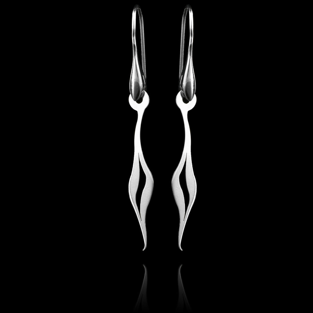 These sterling silver long dangling earrings have thin hangs that drop down and form a teardrop at the bottom. The hangs depict a Haida Gwaii character.