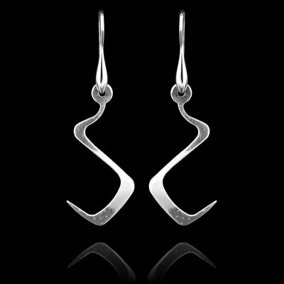 These sterling silver long dangling earrings have thin hangs that drop down and curve in a zig-zag. The hangs depict a Haida Gwaii character.