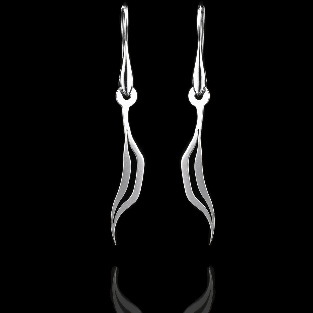These sterling silver long dangling earrings have thin hangs that drop down and curve. The hangs depict a Haida Gwaii character.