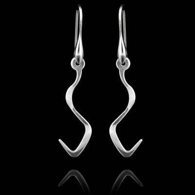 These sterling silver long dangling earrings have thin hangs that drop down and curve in a zig-zag. The hangs depict a Haida Gwaii character.