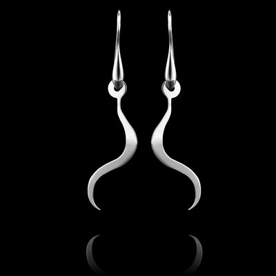 These sterling silver long dangling earrings have thin hangs that drop down and curve. The hangs depict a Haida Gwaii character.