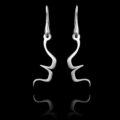 These sterling silver long dangling earrings have thin hangs that drop down and have points protruding from them. The hangs depict a Haida Gwaii character.