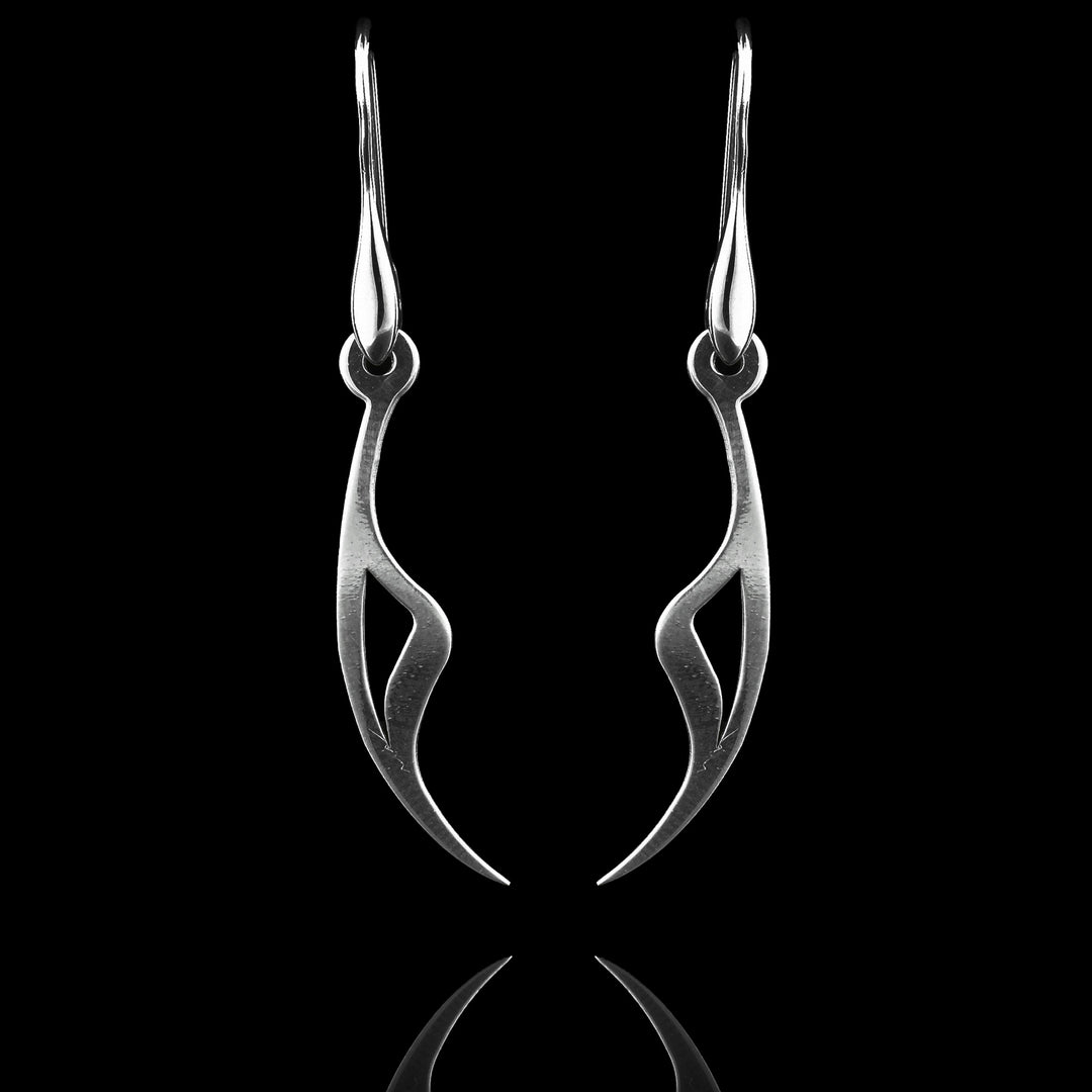 These sterling silver long dangling earrings have thin hangs that drop down and curve. The ends of the hangs have a triangular, claw shape.  The hangs depict a Haida Gwaii character.